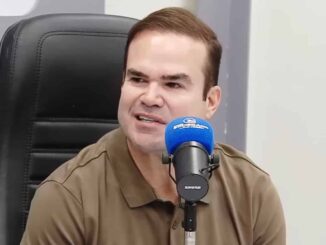Cacá Leão fala ao microfone durante entrevista na Rádio Sociedade.