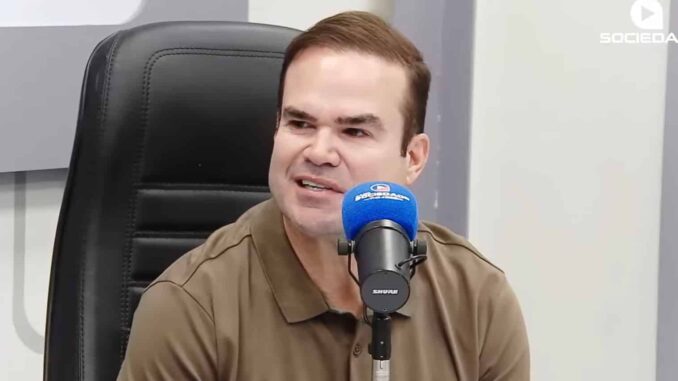 Cacá Leão fala ao microfone durante entrevista na Rádio Sociedade.