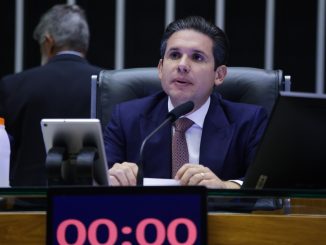 Homem de terno e gravata fala ao microfone durante sessão no plenário da Câmara dos Deputados.