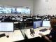 Sala do Centro de Operações e Inteligência da Bahia com profissionais monitorando ocorrências em computadores e telões.