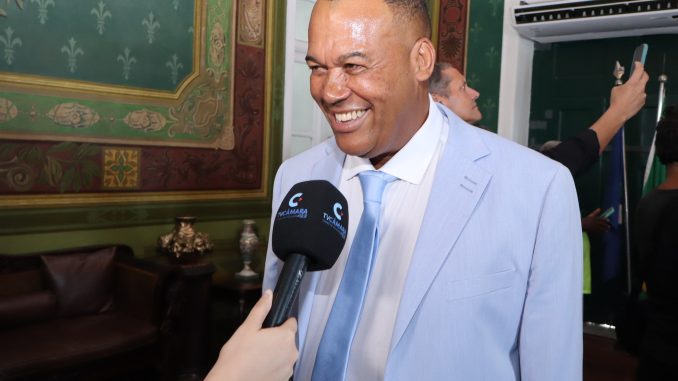 Vereador Beca sorrindo, usando terno, em evento oficial em Salvador.
